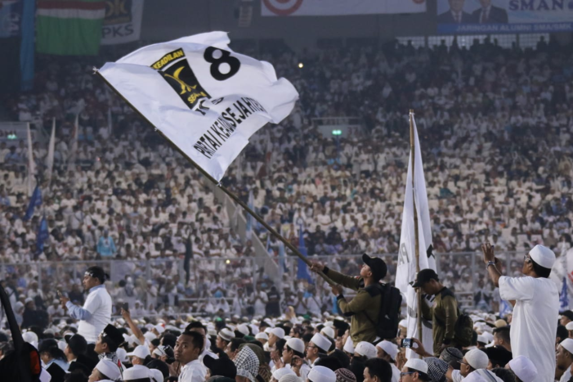 Kader mengibarkan bendera PKS dalam Kampanye Akbar di Stadion GBK, Ahad (7/4) (PKSFoto)