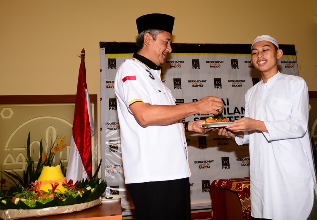 Ketua Panitia Milad ke-19 PKS Ahmad Ru'yat memberikan potongan tumpeng kepada santri Baitul Qur'an dalam tasyakuran Milad ke-19 PKS di kantor DPP PKS Jakarta, Kamis (20/4) (Wara/PKS Foto)