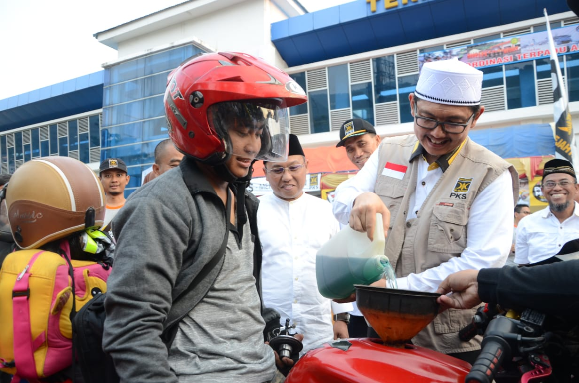Sekretaris Jenderal PKS Mustafa Kamal mengisikan BBM kepada salah satu pemudik yang mampir di Posko Mudik PKS Terminal Terpadu Merak, Cilegon, Banten, Jumat (31/5) (Donny/PKSFoto)