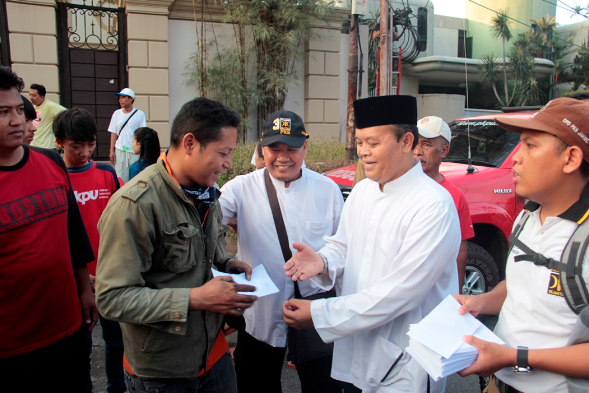 Wakil Ketua MPR RI Hidayat Nur Wahid sedang menyerahkan bantuan kepada warga