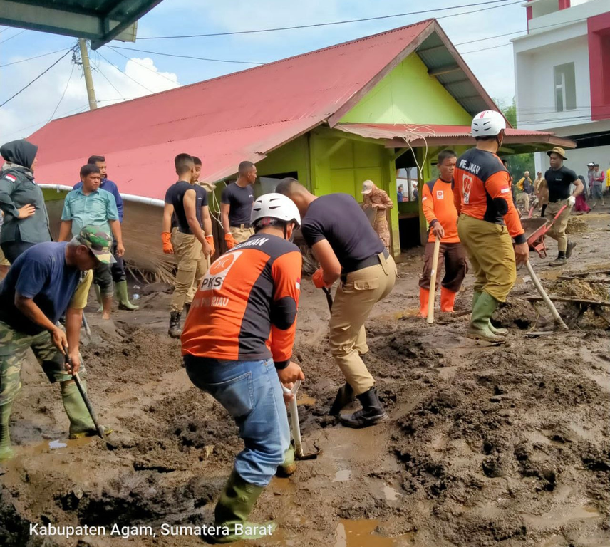 Relawan PKS Riau membantu membersihkan sisa banjir bandang di Sumatera Barat.