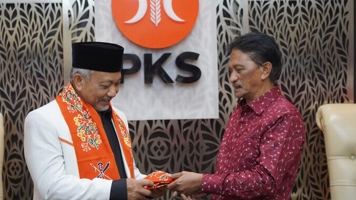 Bakal Calon Bupati Kabupaten Seram Bagian Barat Asri Arman mengalungkan kain berang kepada Presiden PKS Ahmad Syaikhu saat menerima Surat Keputusan (SK) dukungan Pilkada 2024. (PKSFoto/Naufal)