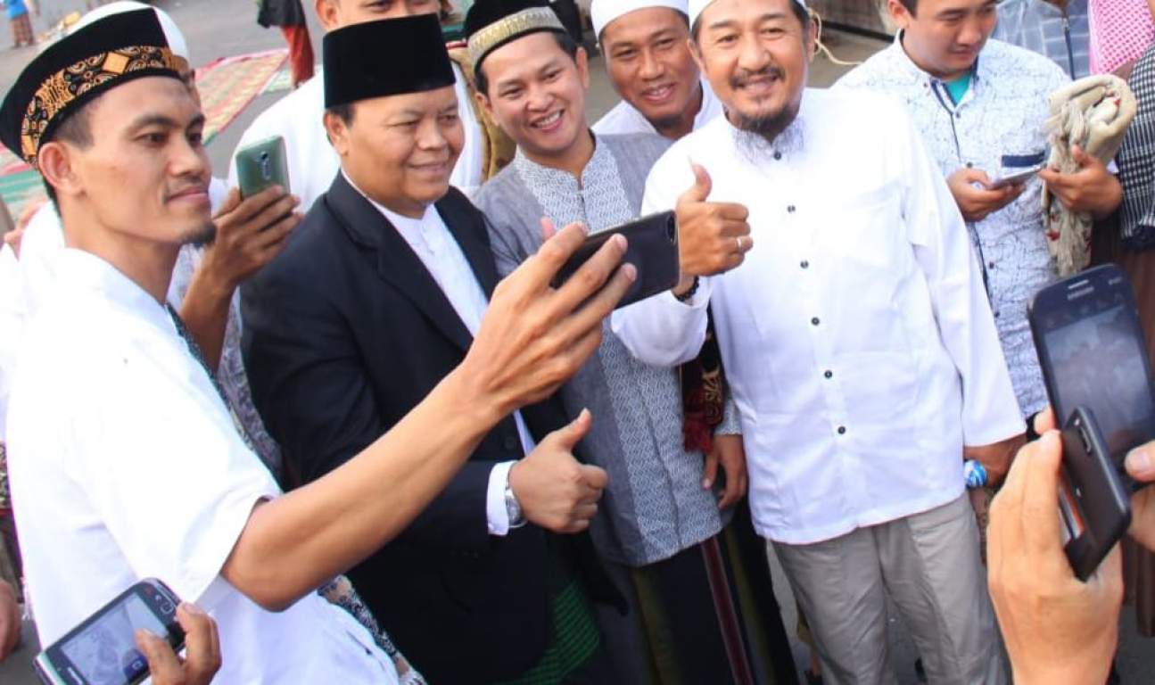 Wakil Ketua Majelis Syuro PKS Hidayat Nur Wahid berswafoto bersama warga usai Shalat Idul Fitri di Kemayoran, Jakarta, Jumat (15/6) (Donny Abui/PKSFoto)