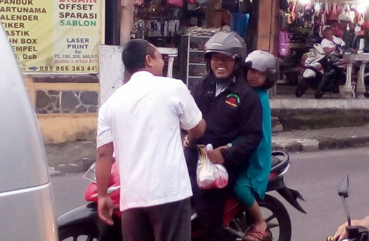 Pembagian Takjil Kepada Pengendara Sepeda Motor