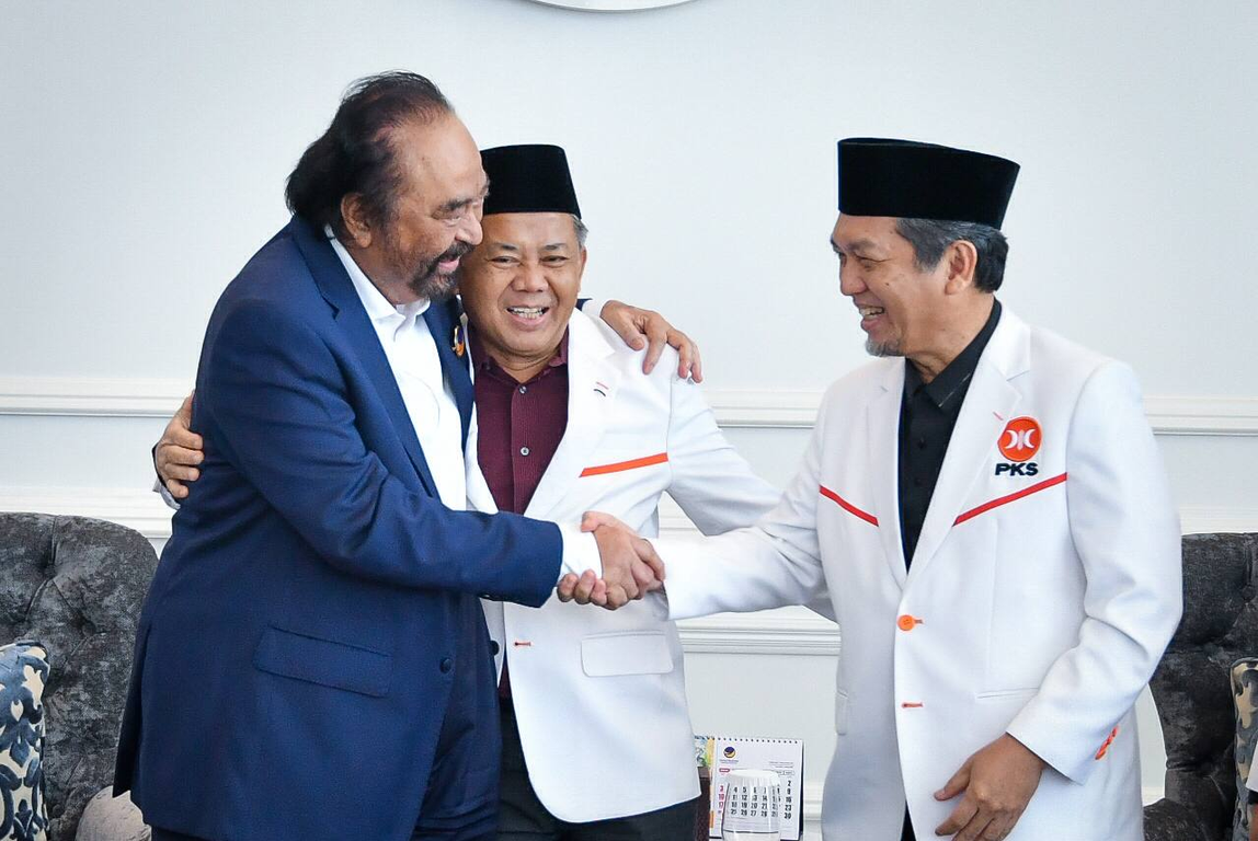 Ketua Majelis Syura PKS Mohamad Sohibul Iman dan Presiden PKS Almuzzammil Yusuf berjabat erat dengan Ketua Umum Partai NasDem Surya Paloh (Fathur/PKSFoto)