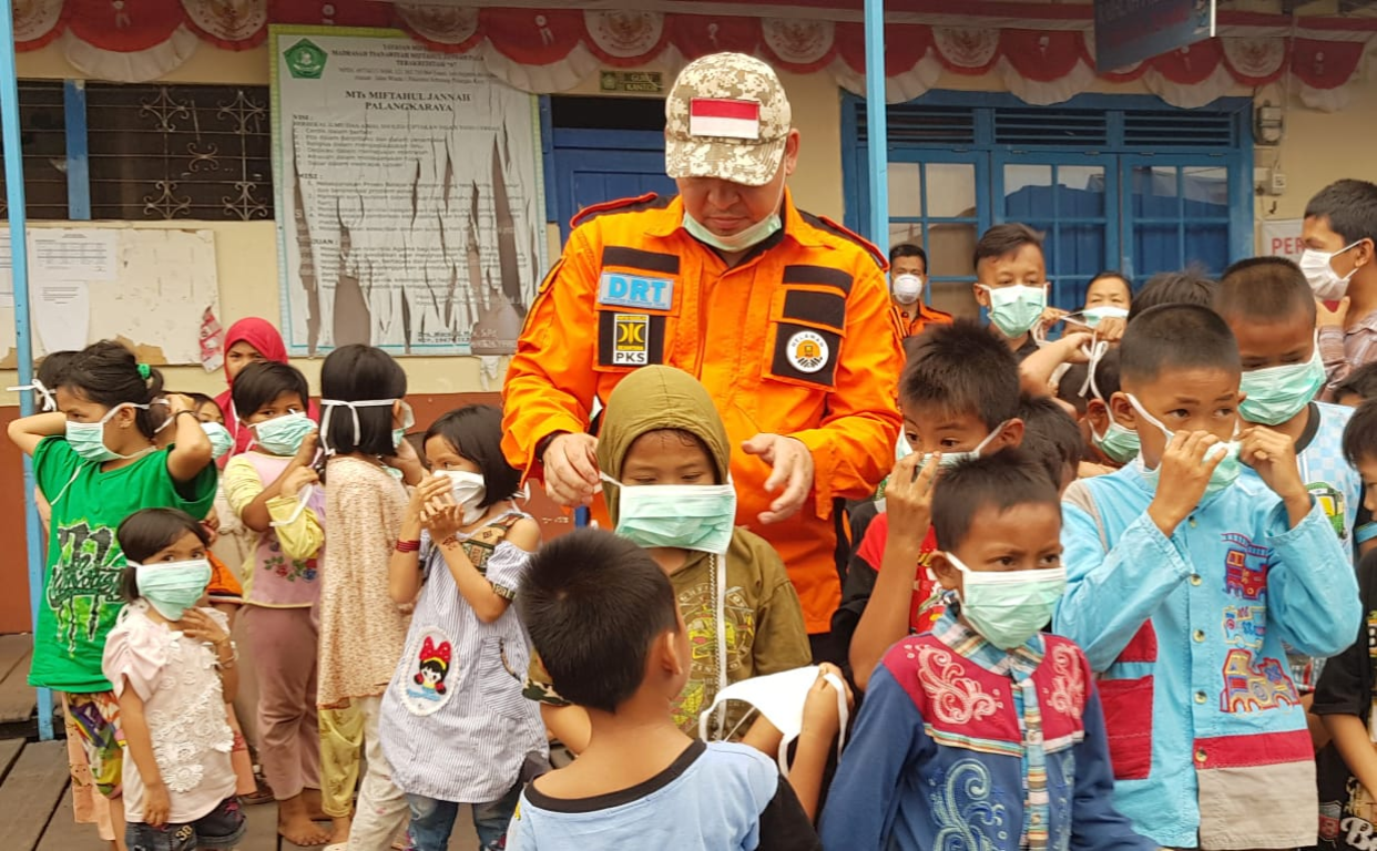 Ketua DPW PKS Kalimantan Tengah Heru Hidayat saat edukasi bahaya asap ke anak-anak, Jumat (20/9) (dok Humas PKS Kalteng)