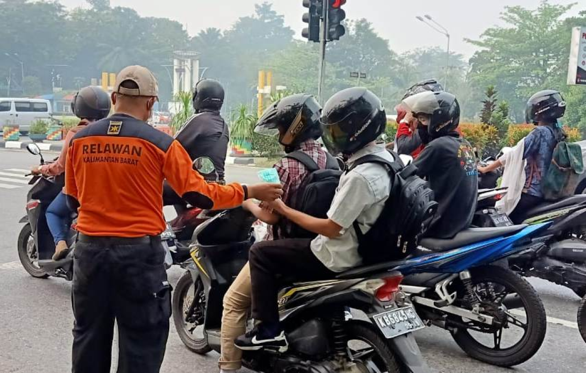 Relawan PKS Kalimantan Barat membagikan masker kepada warga di Pontianak yang terpapar asap Karhutla (Humas PKS Kalbar)