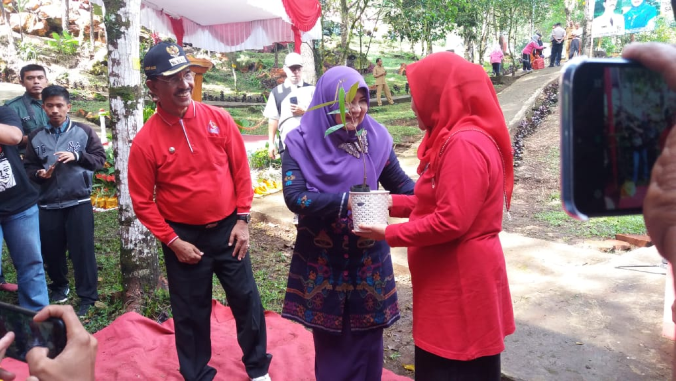 Nevi (kiri) menyerahkan bibit tanaman kepada perwakilan peserta