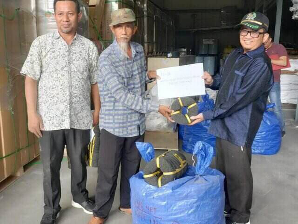 Sekretaris Fraksi PKS DPRD Kota Batam Rohaizat (kanan) menyerahkan bento ketam/kepiting ke nelayan Lubuk Baja