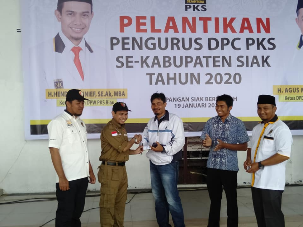 Penyerahan Kartu Tanda Anggota secara simbolis dari Ketua DPW PKS Riau Hendry Munief ke perwakilan peserta yang dilantik, Siak, Riau, Ahad (19/01/2020)