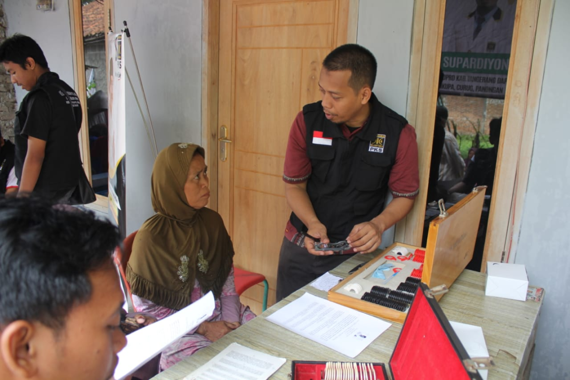 Relawan PKS tampak sedang melayani warga yang memeriksa mata di Desa Ciakar, Panongan, Ahad (13/1) (dok Humas PKS Kab Tangerang)