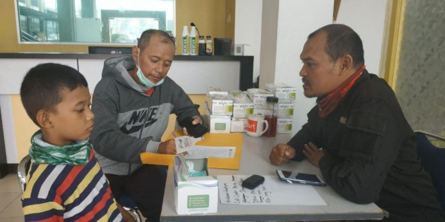 Seorang warga membawa anak untuk diperiksa di Pos Penanggulangan Kabut Asap PKS Riau (Humas PKS Riau)